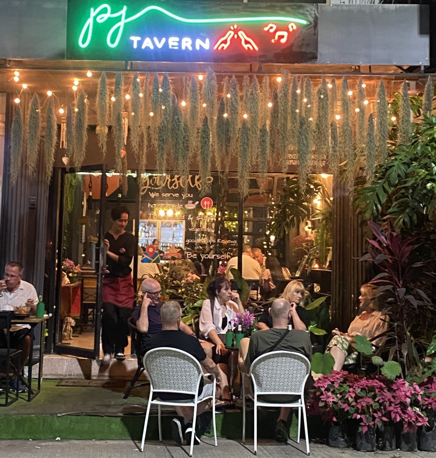 Front entrance of PJ Tavern Thai restaurant in Pattaya with guests enjoying dinner in a warm and welcoming atmosphere.